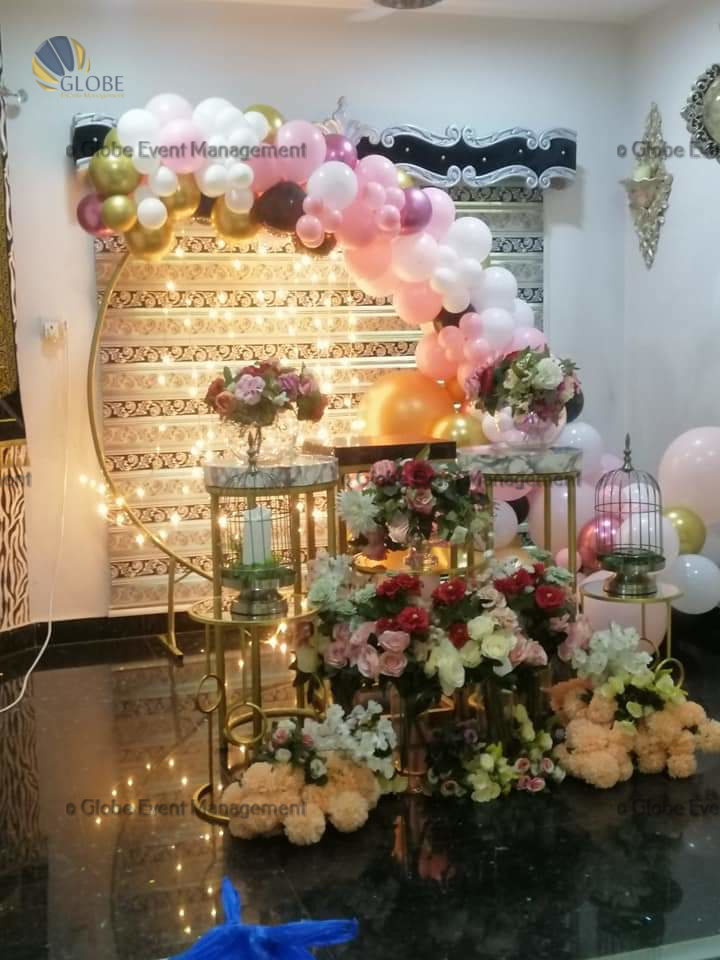 Professionally organized corporate seminar with stage and seating arrangements. Stylish product launch event setup with lights and branded backdrops. Corporate gala dinner with elegant table decor and ambient lighting. Annual day event with large LED screens and stunning stage setup. Beautifully arranged outdoor seating for a private party event. Event management team setting up a large stage for a gala night. Stunning decor featuring floral arches and chandeliers for an event. Table setup with elegant glassware and centerpiece for a formal event. Stunning flower decoration for a grand wedding entrance. Outdoor event lighting with string lights and lanterns creating a magical ambiance. Creative flower arrangement for a corporate event stage. Romantic candlelight decor with floral centerpieces for a party. Wedding Planners in Bangalore