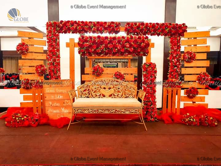 Professionally organized corporate seminar with stage and seating arrangements. Stylish product launch event setup with lights and branded backdrops. Corporate gala dinner with elegant table decor and ambient lighting. Annual day event with large LED screens and stunning stage setup. Beautifully arranged outdoor seating for a private party event. Event management team setting up a large stage for a gala night. Stunning decor featuring floral arches and chandeliers for an event. Table setup with elegant glassware and centerpiece for a formal event. Stunning flower decoration for a grand wedding entrance. Outdoor event lighting with string lights and lanterns creating a magical ambiance. Creative flower arrangement for a corporate event stage. Romantic candlelight decor with floral centerpieces for a party. Wedding Planners in Bangalore