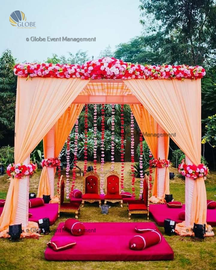 Professionally organized corporate seminar with stage and seating arrangements. Stylish product launch event setup with lights and branded backdrops. Corporate gala dinner with elegant table decor and ambient lighting. Annual day event with large LED screens and stunning stage setup. Beautifully arranged outdoor seating for a private party event. Event management team setting up a large stage for a gala night. Stunning decor featuring floral arches and chandeliers for an event. Table setup with elegant glassware and centerpiece for a formal event. Stunning flower decoration for a grand wedding entrance. Outdoor event lighting with string lights and lanterns creating a magical ambiance. Creative flower arrangement for a corporate event stage. Romantic candlelight decor with floral centerpieces for a party. Wedding Planners in Bangalore